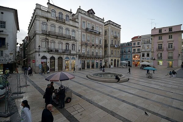 Praça 8 de Maio em Coimbra, com edifícios históricos e a fonte no centro