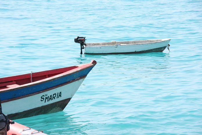 Barcos de pesca na água turquesa de Santa Maria, na ilha do Sal, Cabo Verde